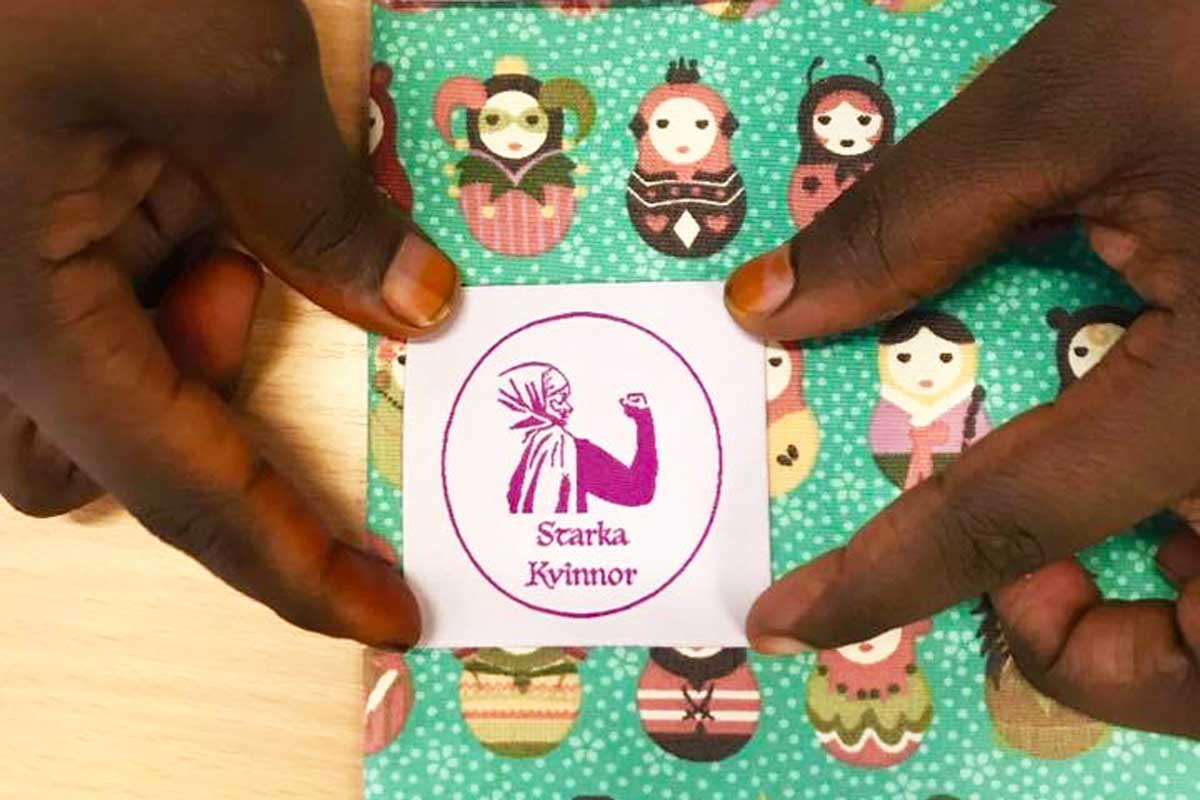 Syprojekt starka kvinnor händer som håller tyg med logotyp starka kvinnor