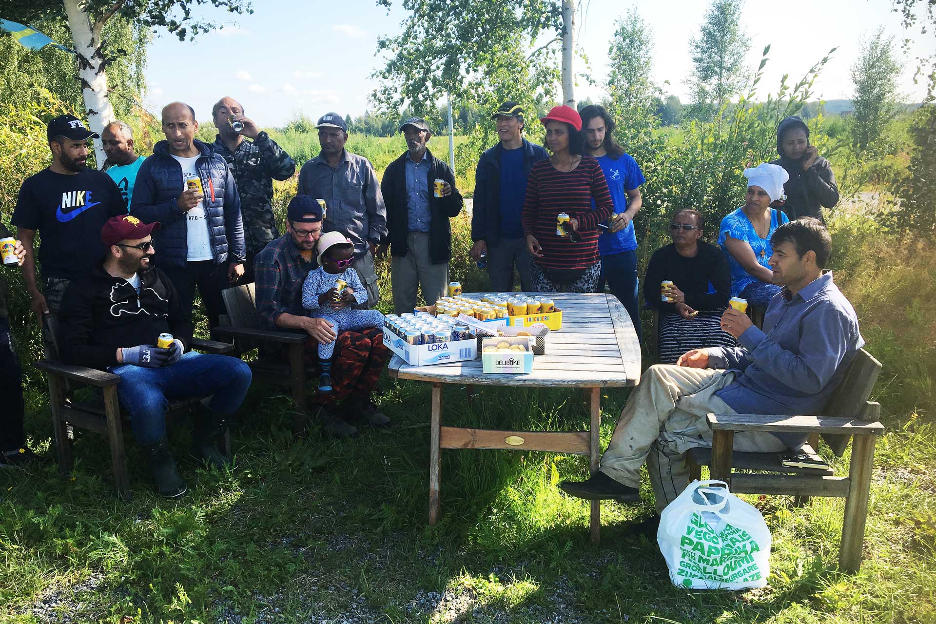 Stadsnära odling i Gammelbyn stor grupp samlad utomhus dricker trocadero-läsk