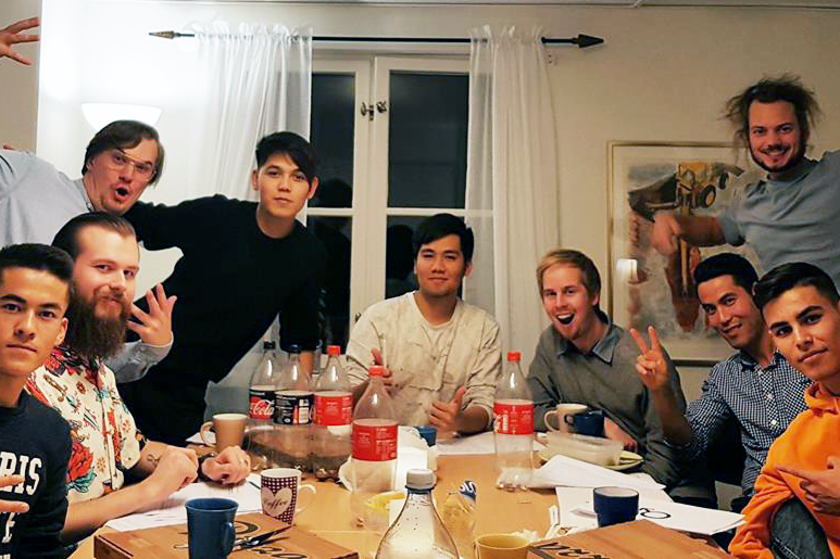 Mixed group of young men having dinner